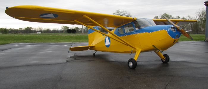 The restored yellow Stinson 10 in flight